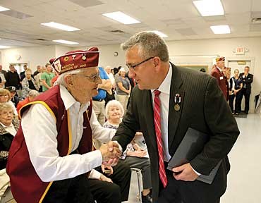 Former POW Rocky Sickmann, right, shakes hands with World War II POW Bill Koeln at the Sept. 16 National POW-MIA Recognition Day event. photo by Ursula Ruhl, South County Times.